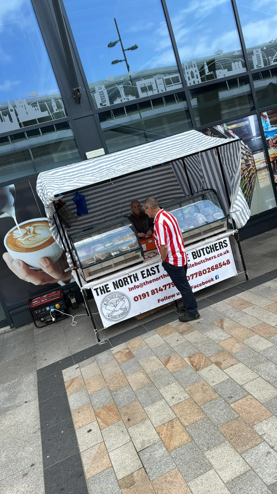 The North East Mobile Butchers market stall serving a customer at a local event
