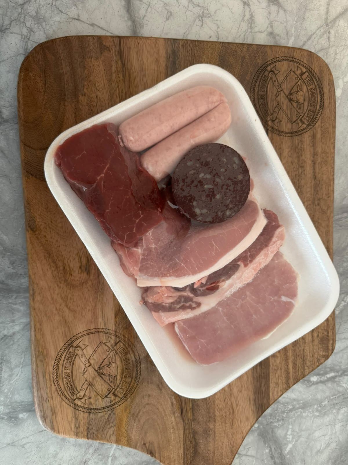 A genuine NEMB breakfast pack — steak, sausages, black pudding and bacon on an engraved North East Mobile Butchers board